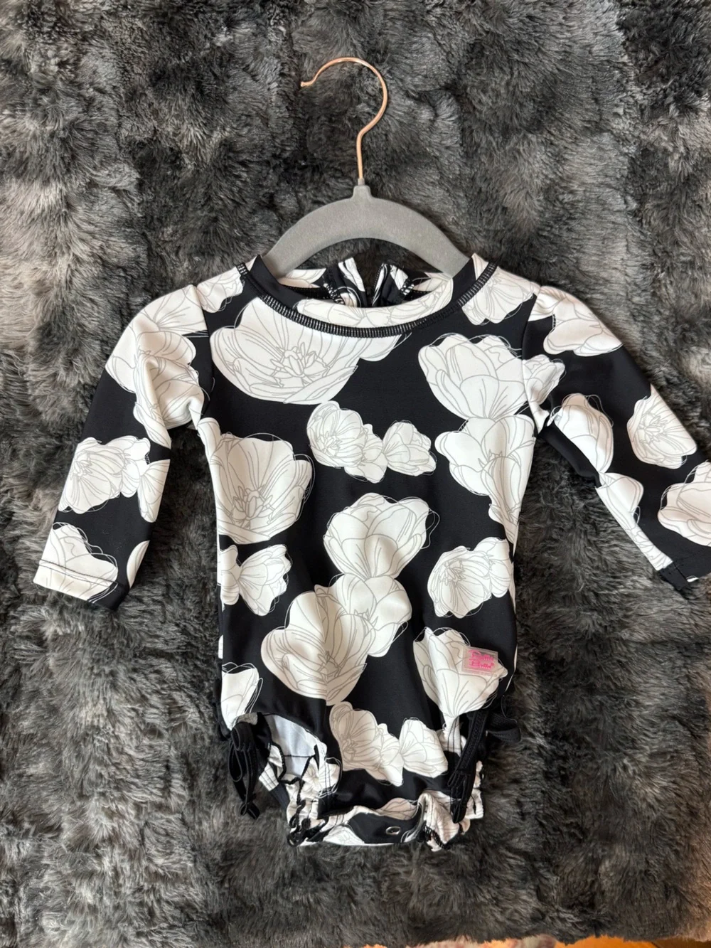 Rufflebutts Black Floral Long Sleeve Rashguard Swimsuit with White Flower Print